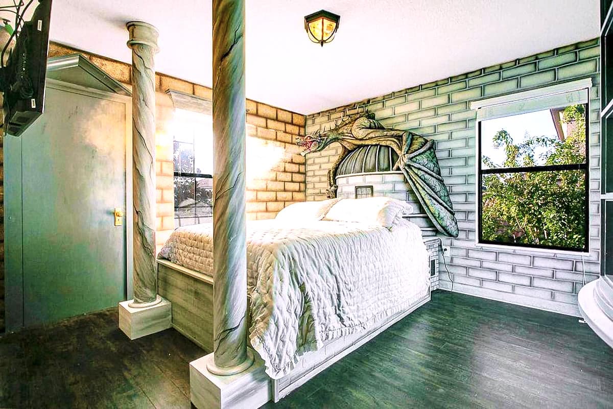 A 7-ft dragon inspired by the Gringotts Ukrainian Ironbelly coiled above the headboard, red