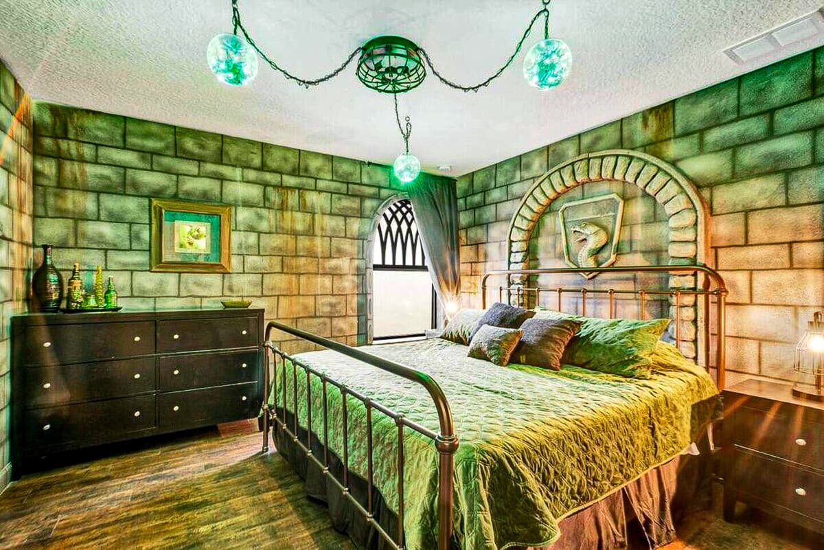 Green dungeon light, stone walls, a serpent crest glowing above the iron-frame b