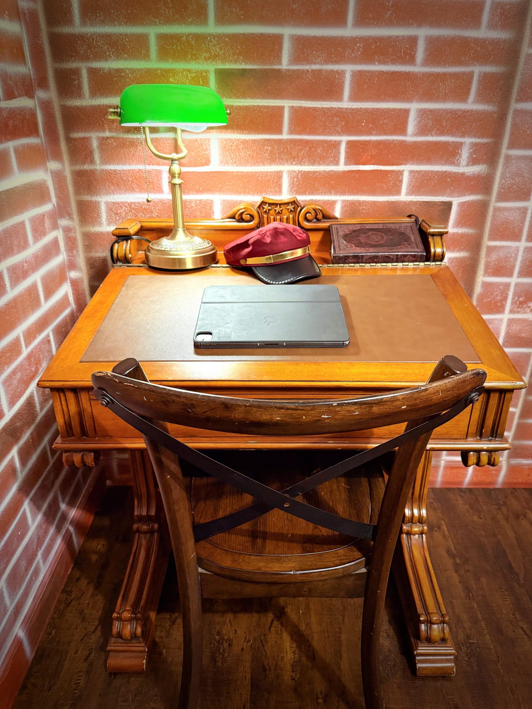 Leather writing surface, carved oak legs, and a conductor's cap resting beside a