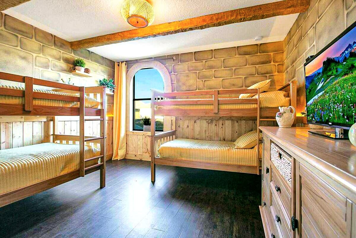 The Honeylight Suite. Honey-toned wooden bunks, soft golden light through an arc