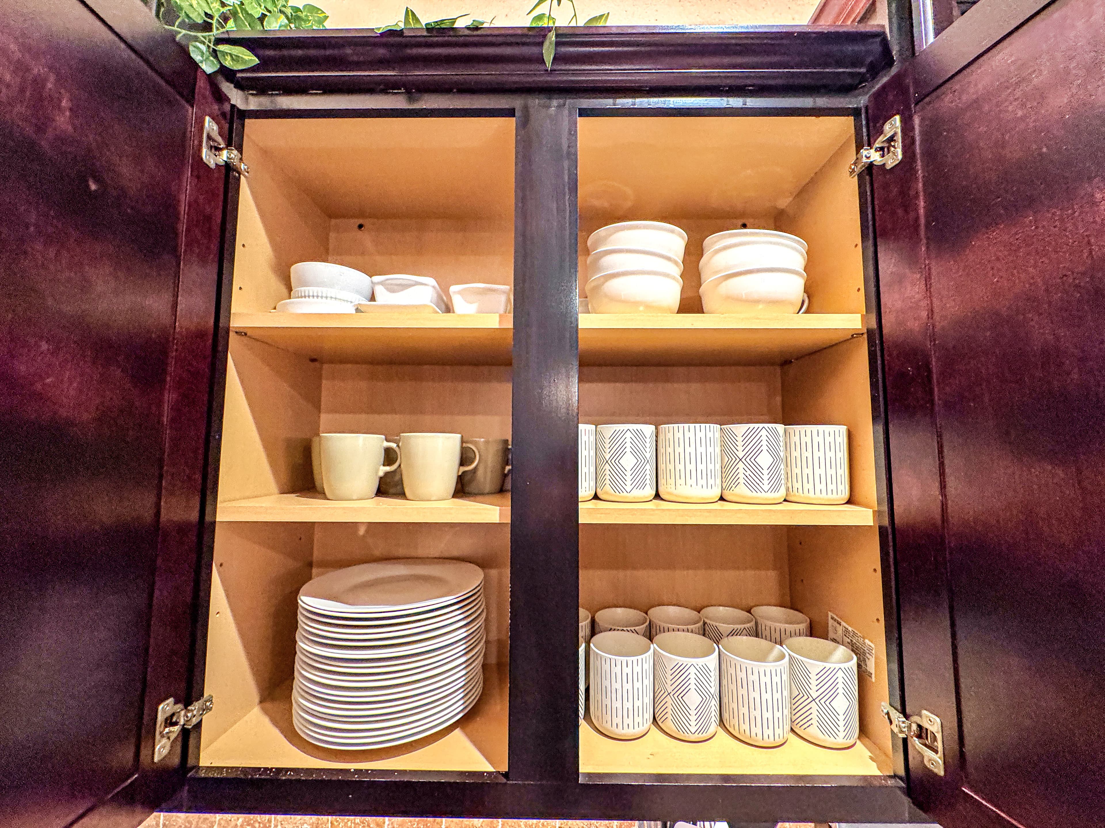 Every cabinet stacked deep — dishes, bowls, and 21 geometric rune mugs. Morning