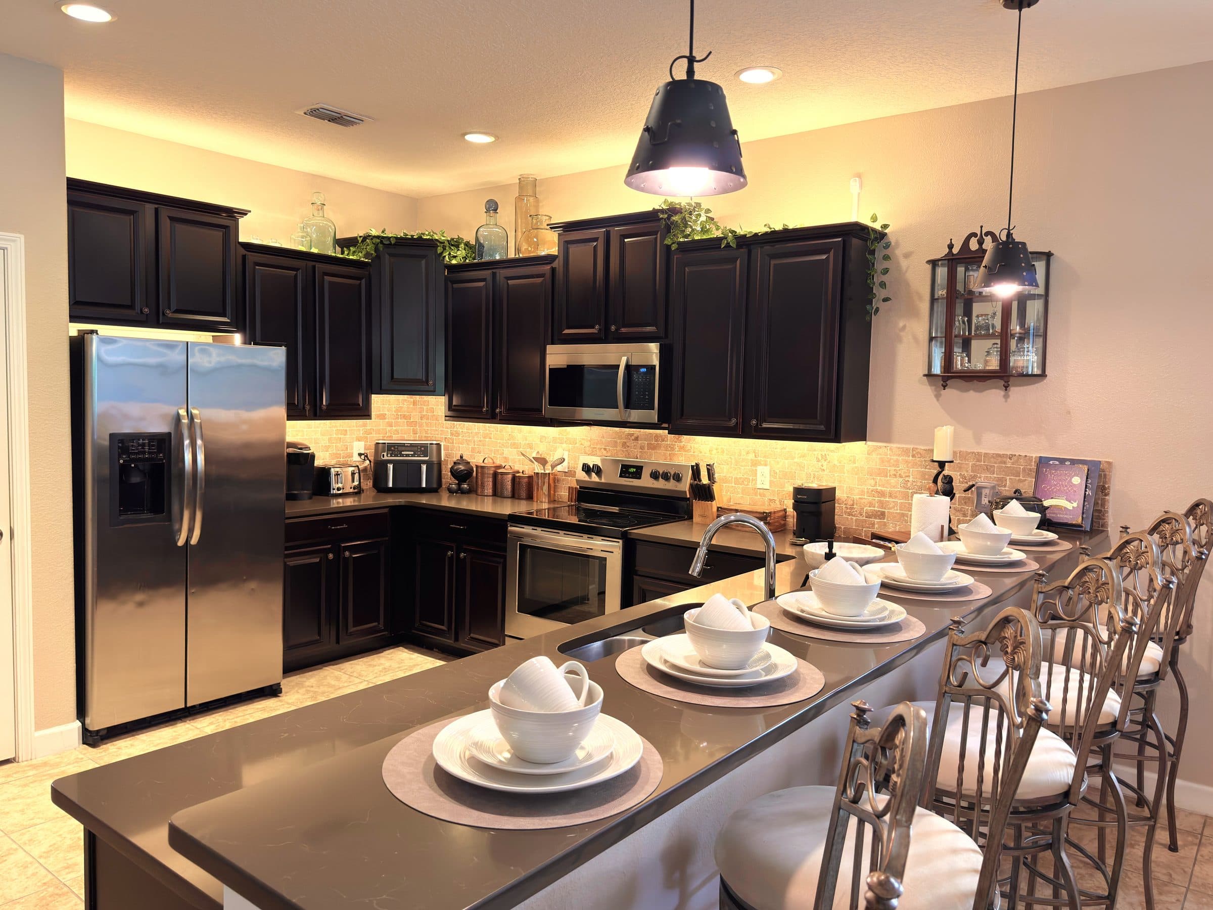 Dark cabinetry, stainless steel, Ninja air fryer, four-slot toaster, granite isl
