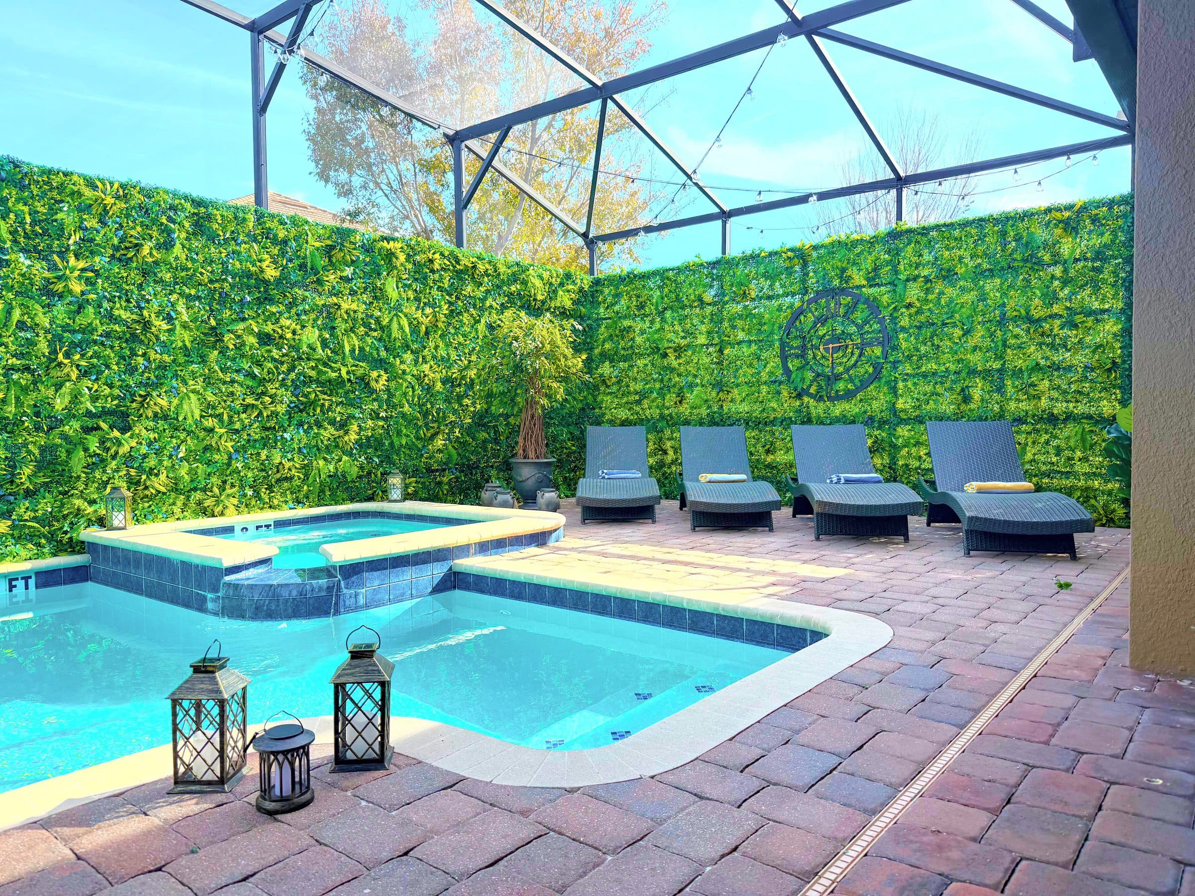 Six loungers lined up, spillover spa steaming, weathered stone urns and trailing