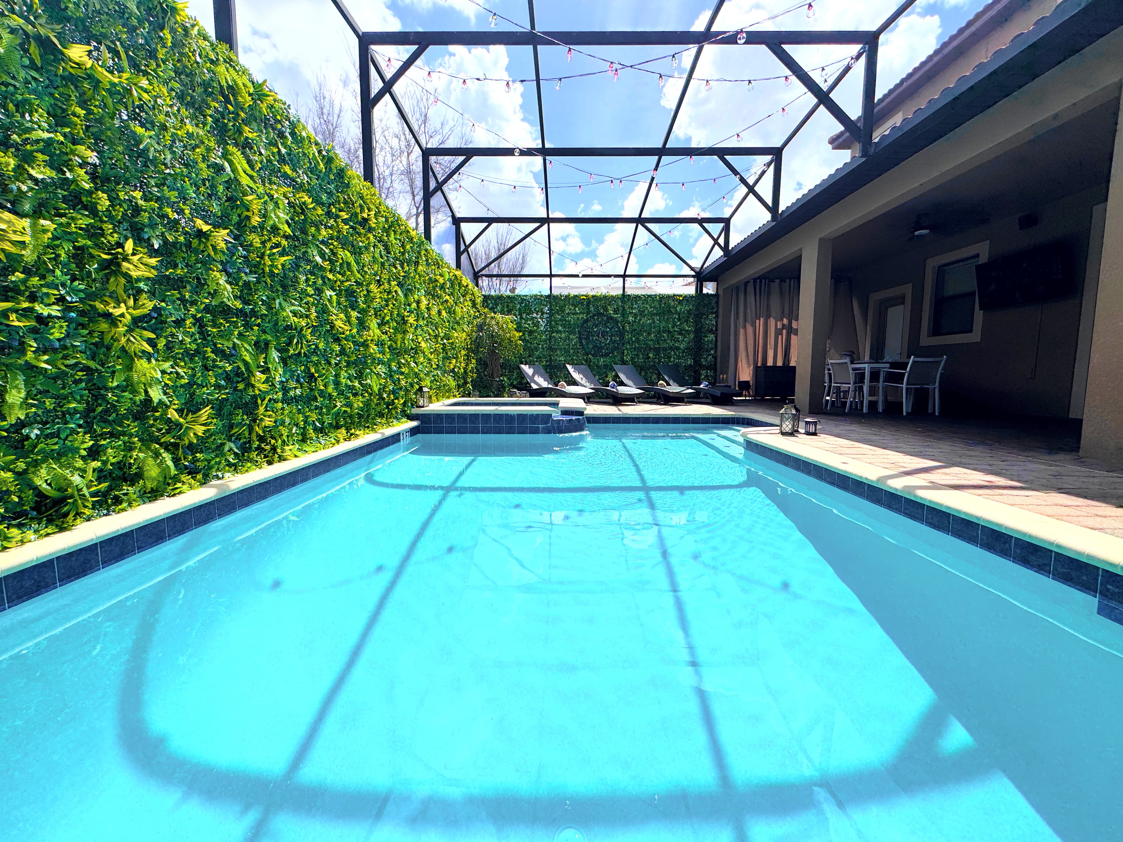 Sun-drenched and screened in, privacy hedge wrapping the enclosure — the heated