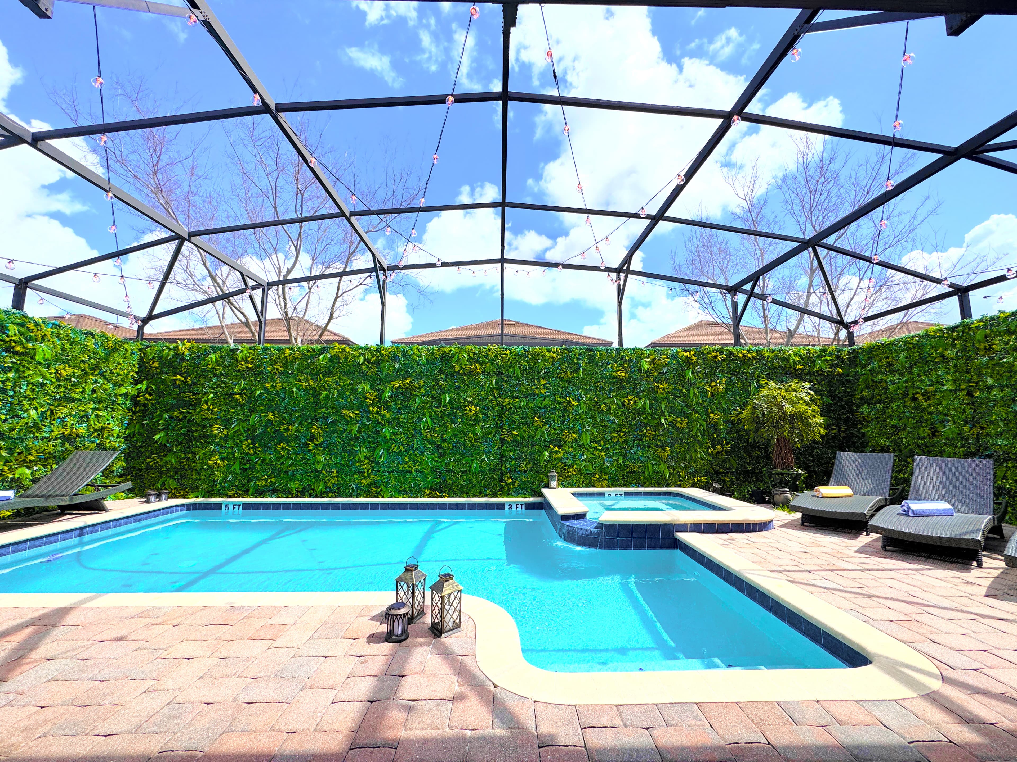 Heated pool, spillover spa, and a private screened enclosure draped in green. No