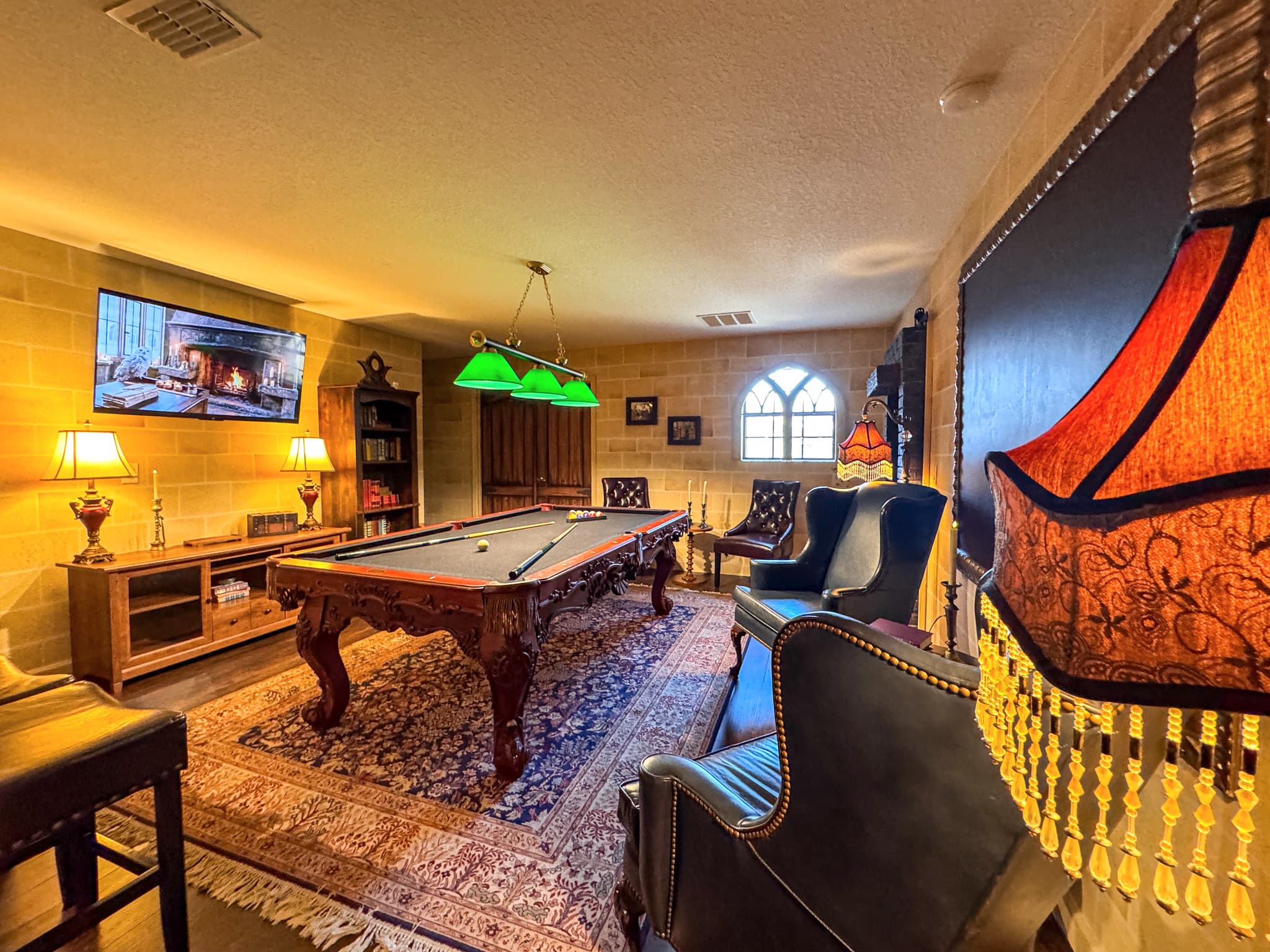 Gothic stone windows filter soft light. A Tiffany lamp throws amber across the P