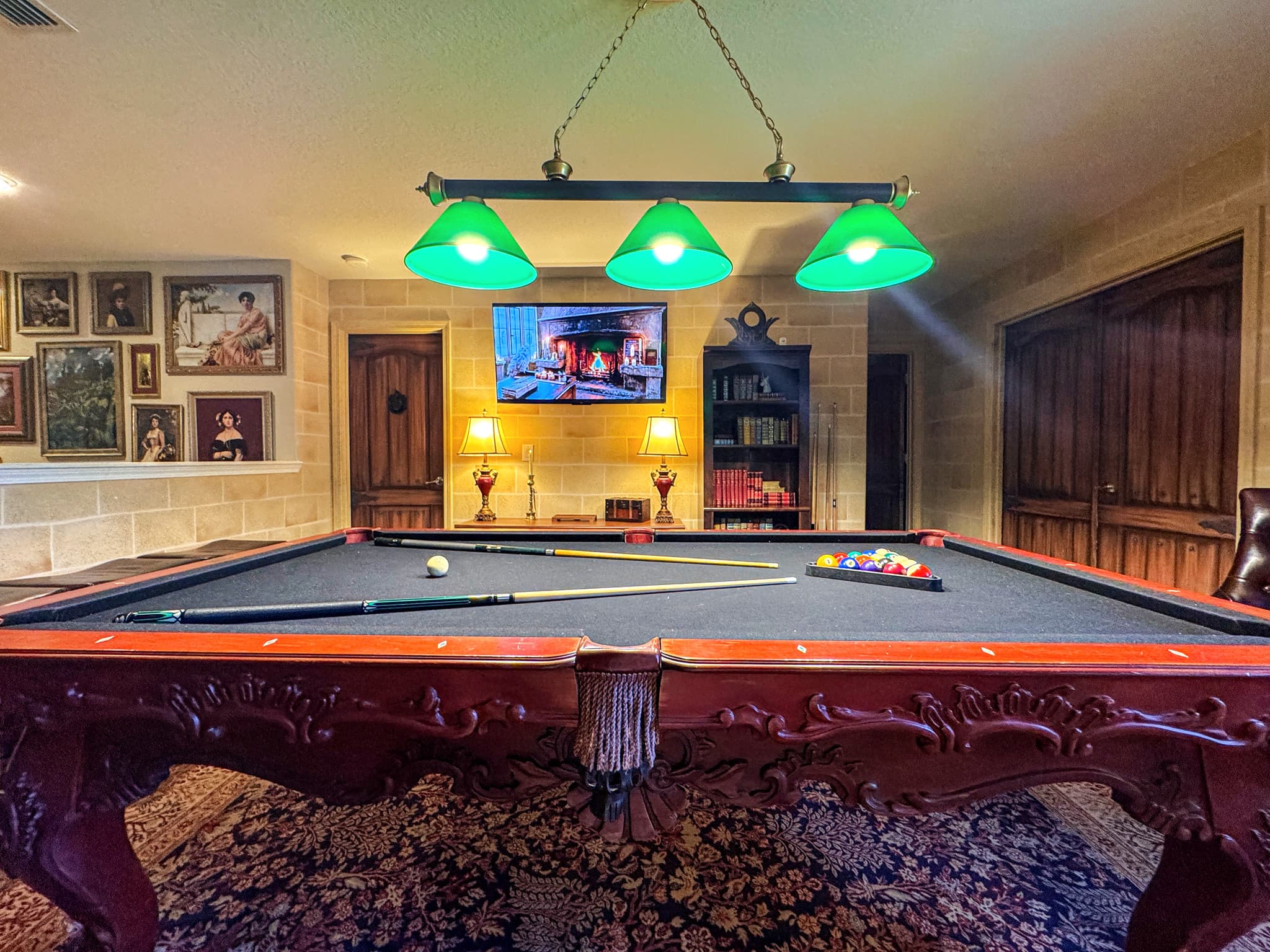 Looking down the felt toward the fireplace glow on the wall-mounted screen, gree