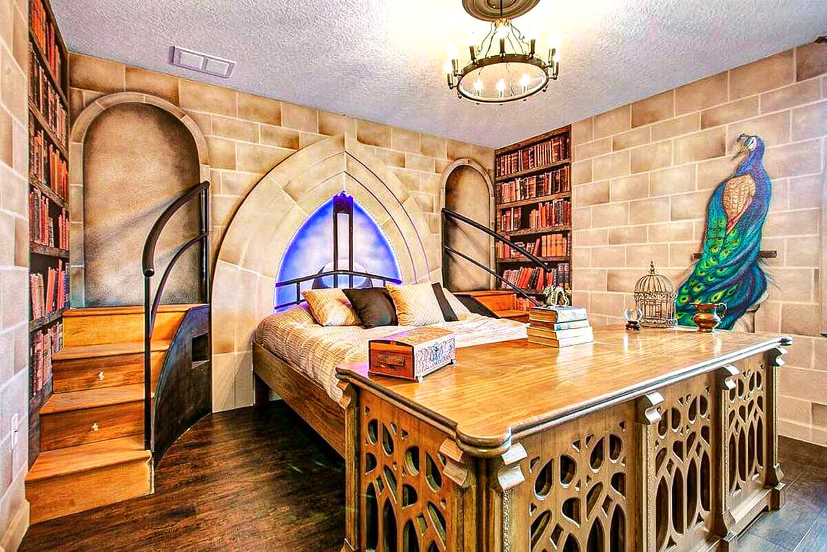 Hand-carved desk inspired by Dumbledore's study anchors the foot of the bed. Gothic stone arches,